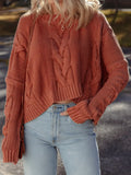 Woman wearing Cable Knit Sweater with chunky slouchy fit and textured design in a warm outdoor setting.