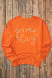 Orange Game Day Sweatshirt with round neck and long sleeves on wooden background