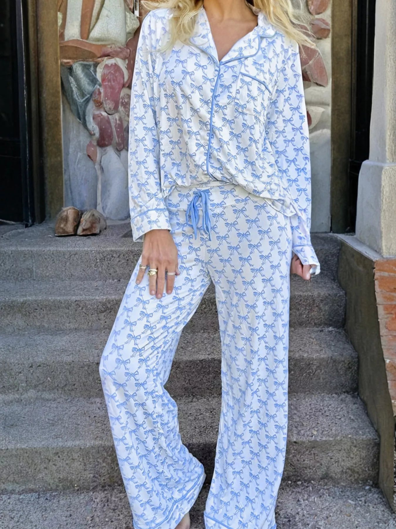 Woman wearing Bow Print Pajama Set by Felvior with a long sleeve shirt and pants, showcasing comfort and style.