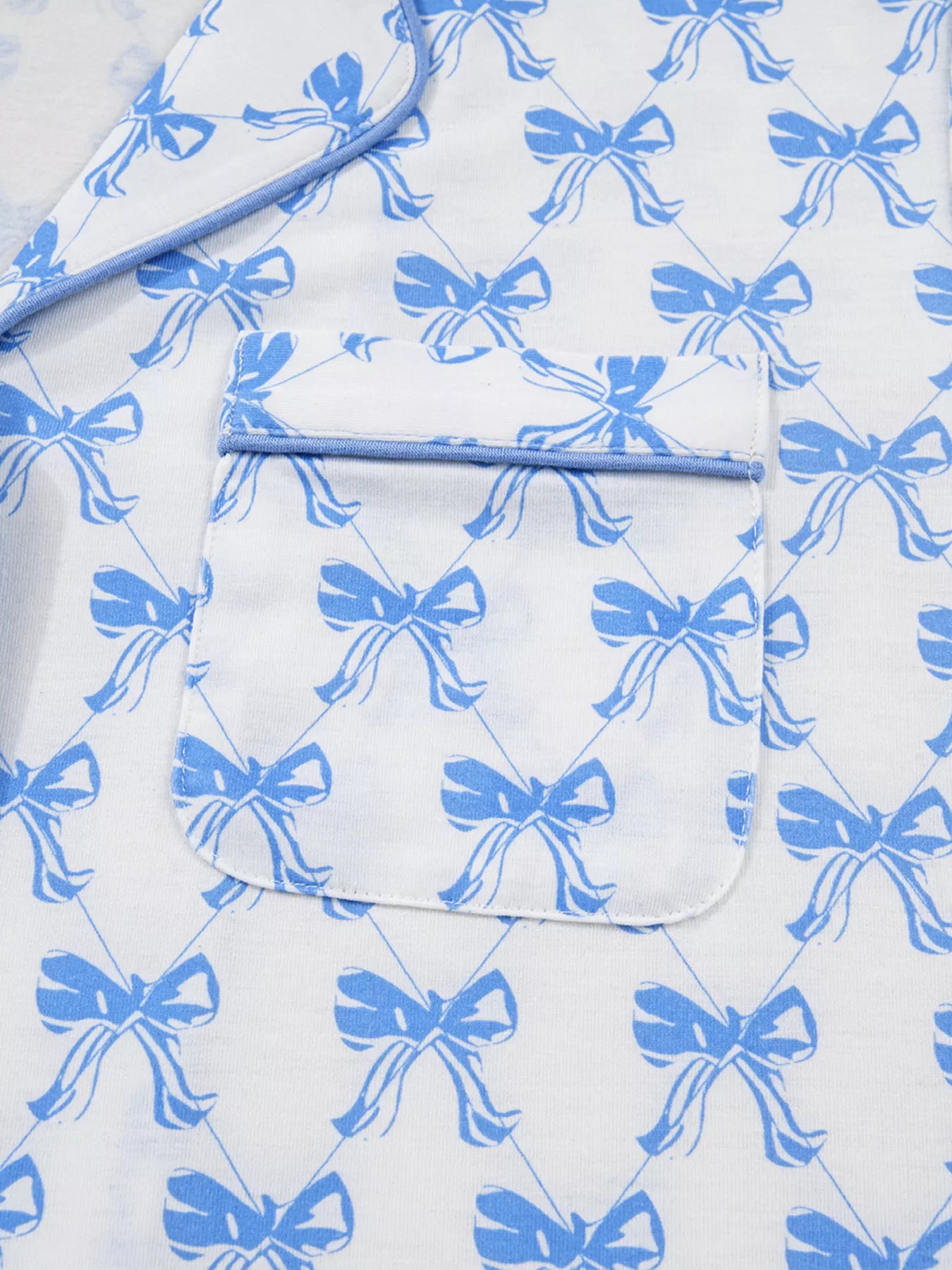 Bow Print Pajama Set by Felvior showcasing a blue bow pattern on a white background with a close-up of the pocket detail.
