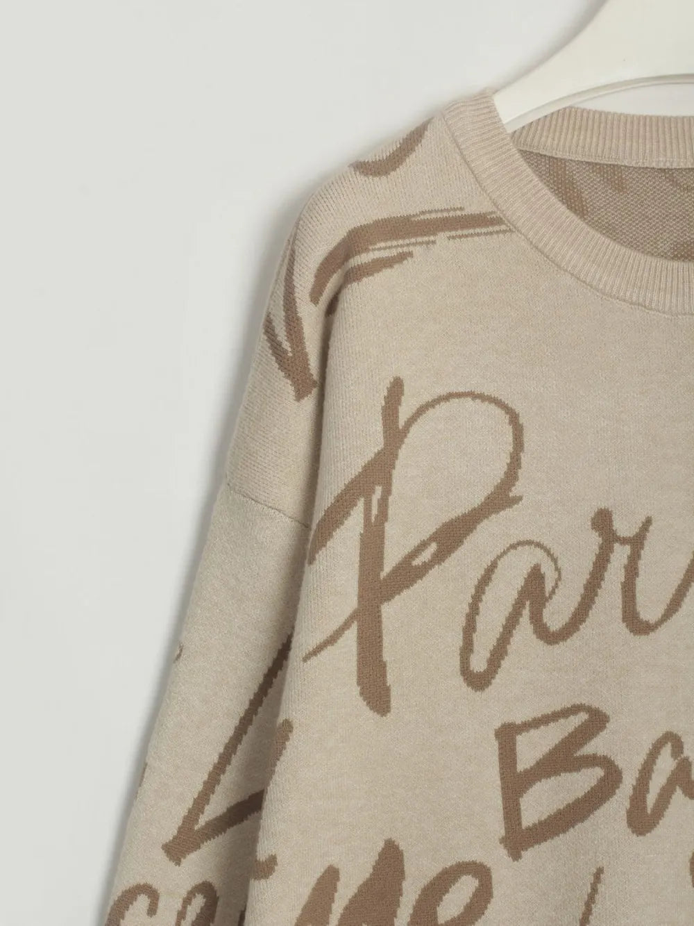 Letter Pattern Sweater with drawstring hem and dropped shoulder design in neutral tones, displaying stylish letter detail.