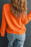 Person wearing orange Game Day Sweatshirt with long sleeves and round neck, paired with jeans.