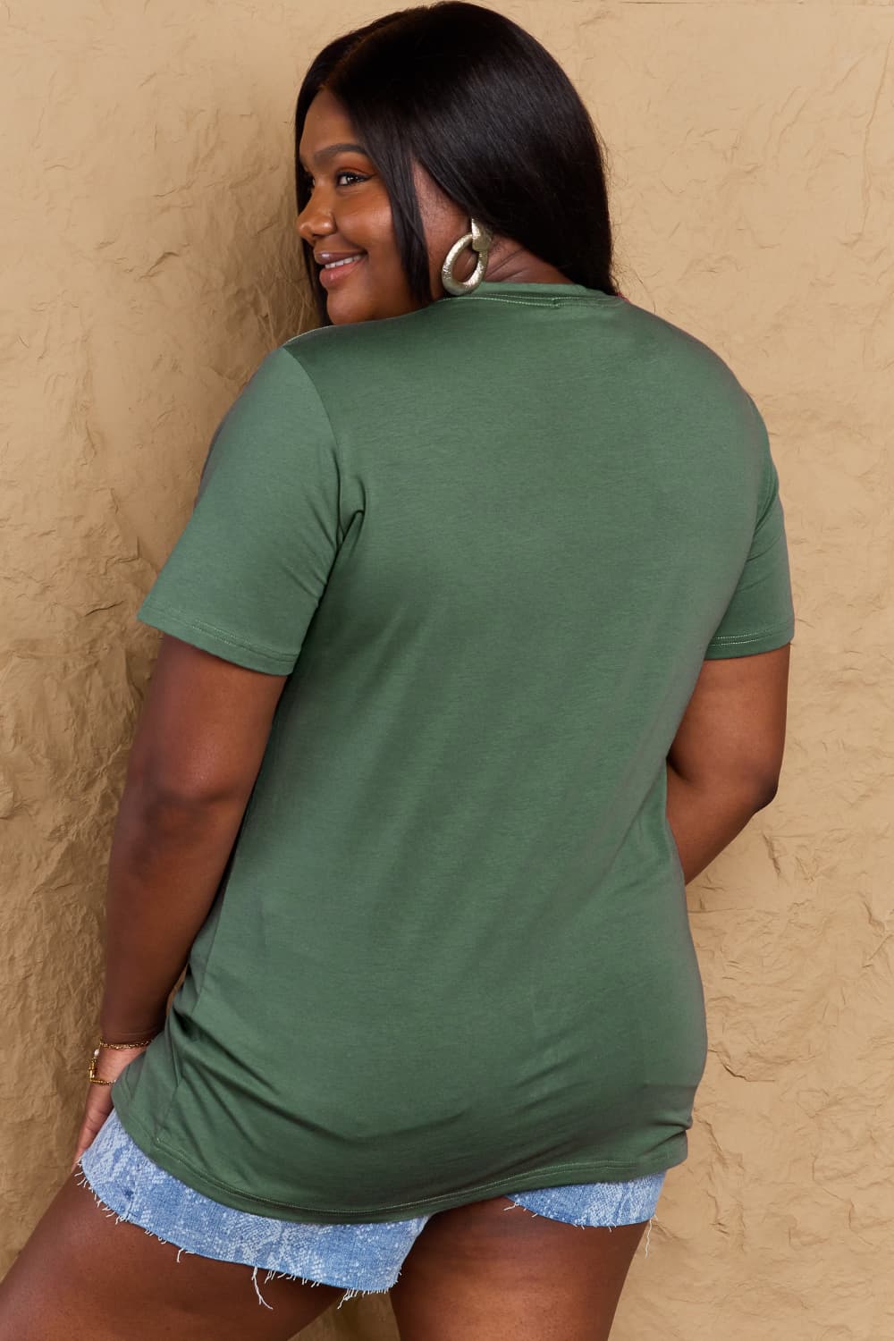 Woman wearing a casual green Graphic Cotton T-Shirt, showcasing the full-size fit from behind.