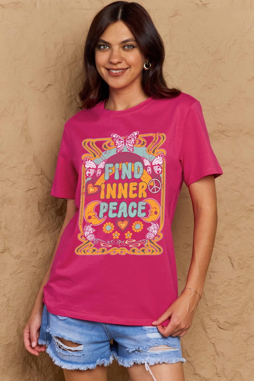 Woman wearing Graphic Cotton T-Shirt with 'FIND INNER PEACE' print in vibrant colors, styled casually for a relaxed look.