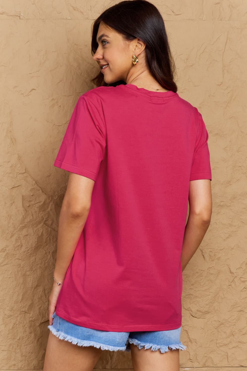 Back view of woman wearing Graphic Cotton T-Shirt in pink, showcasing comfort and style with "FIND INNER PEACE" print.