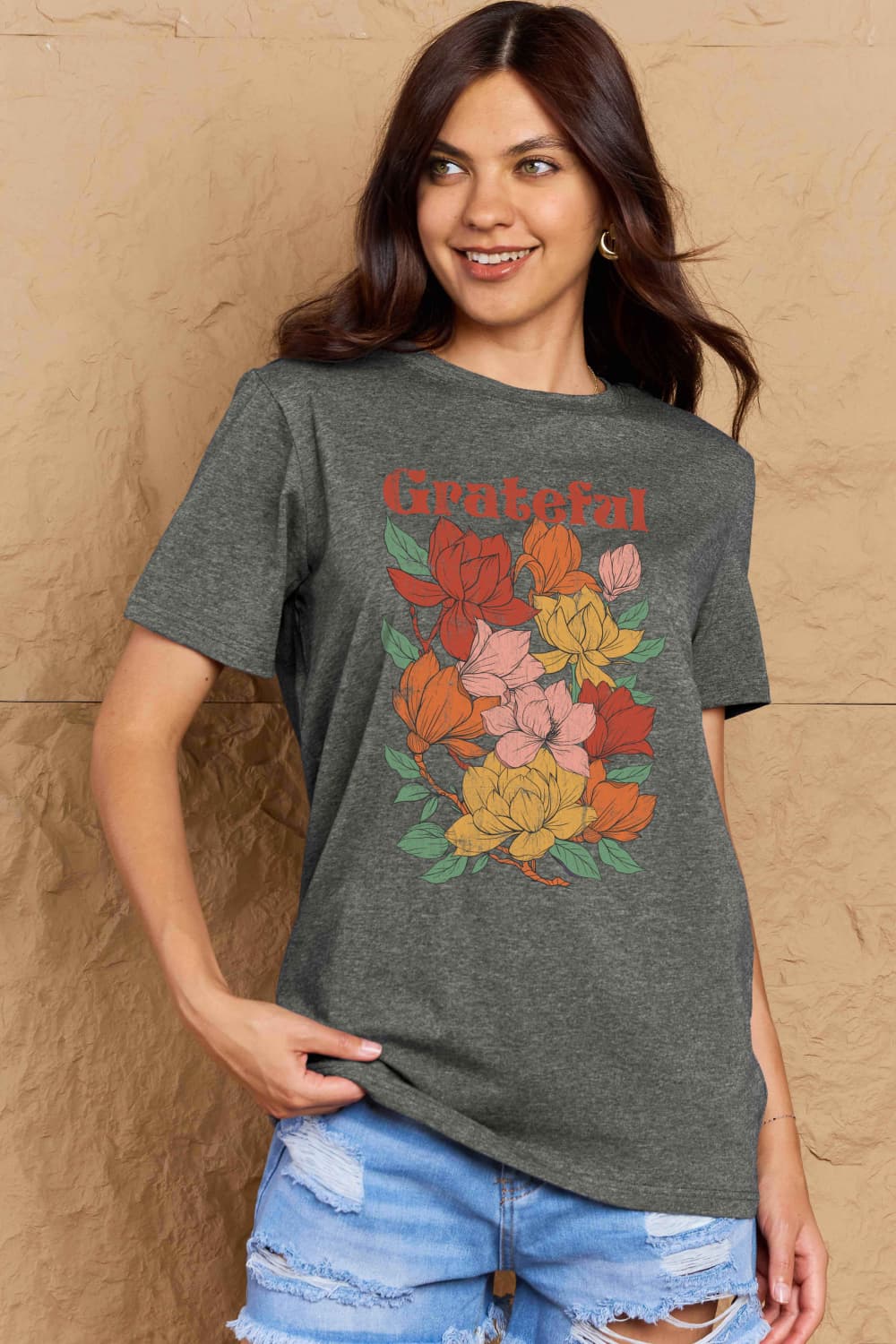 Woman wearing Graphic Cotton T-Shirt with 'GRATEFUL' flower print, showcasing positive energy and casual style.
