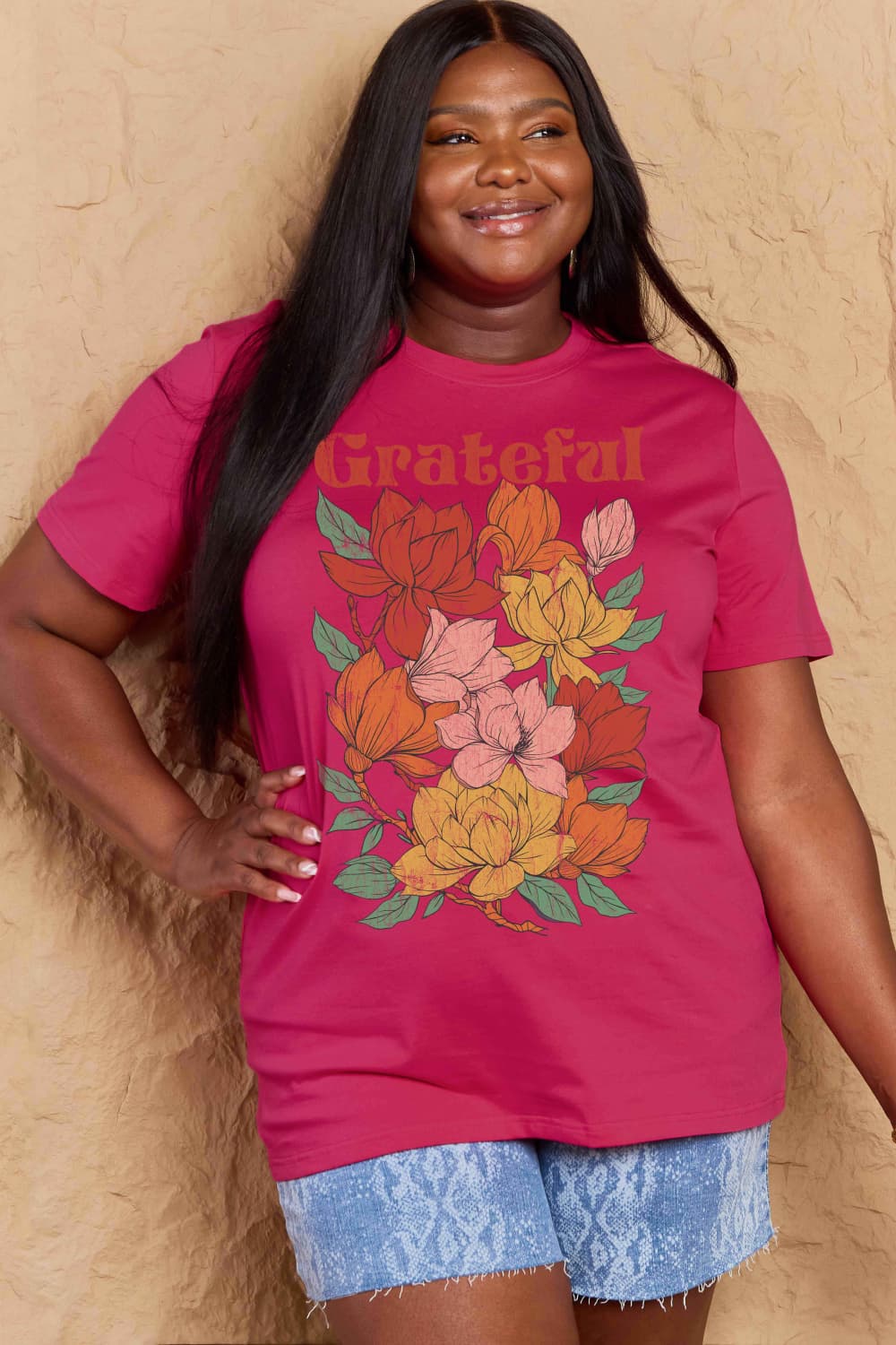 Woman wearing Graphic Cotton T-Shirt with GRATEFUL flower print, showcases casual style and comfort.