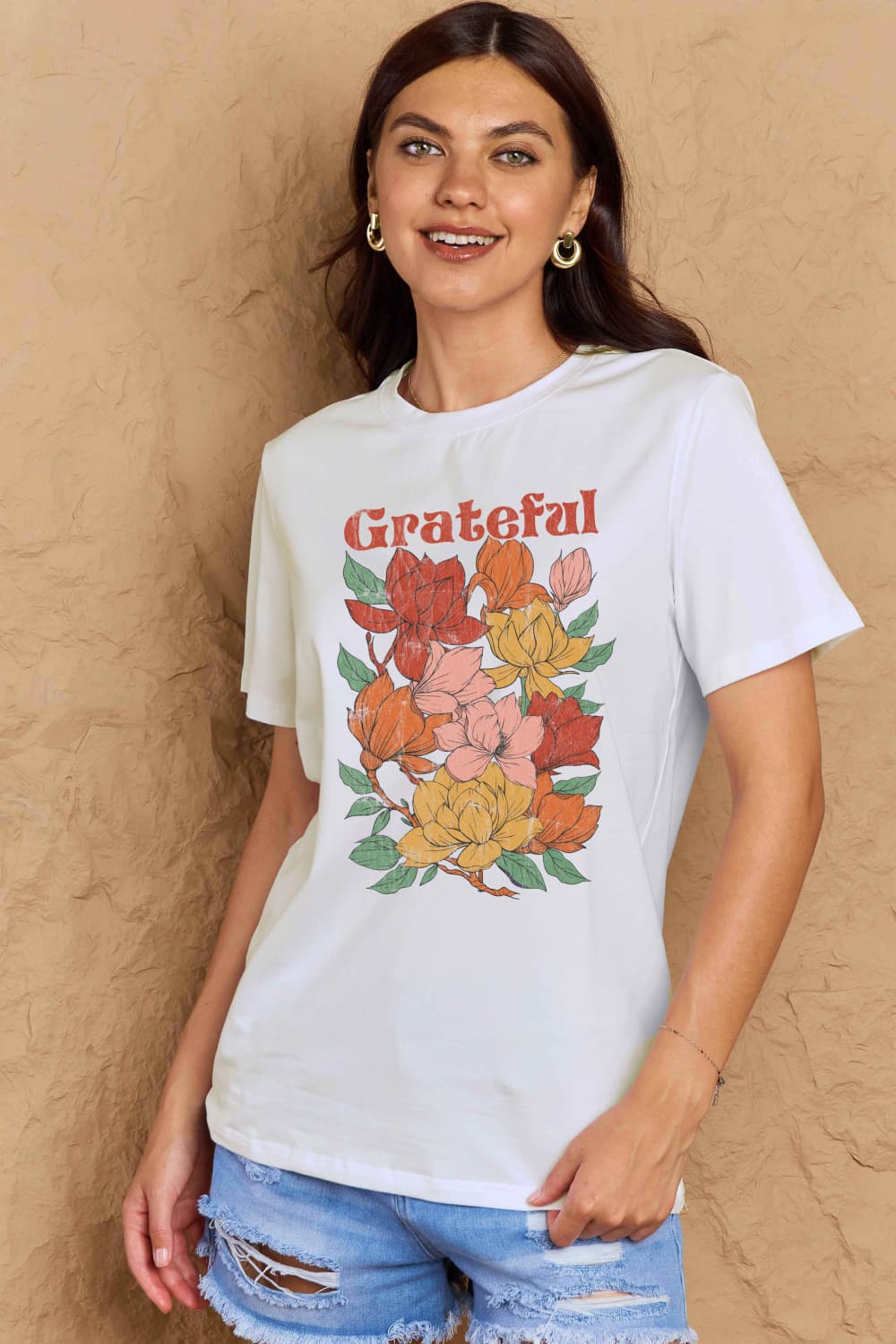 Woman wearing Graphic Cotton T-Shirt with 'GRATEFUL' flower print, casual attire for spreading positive energy.