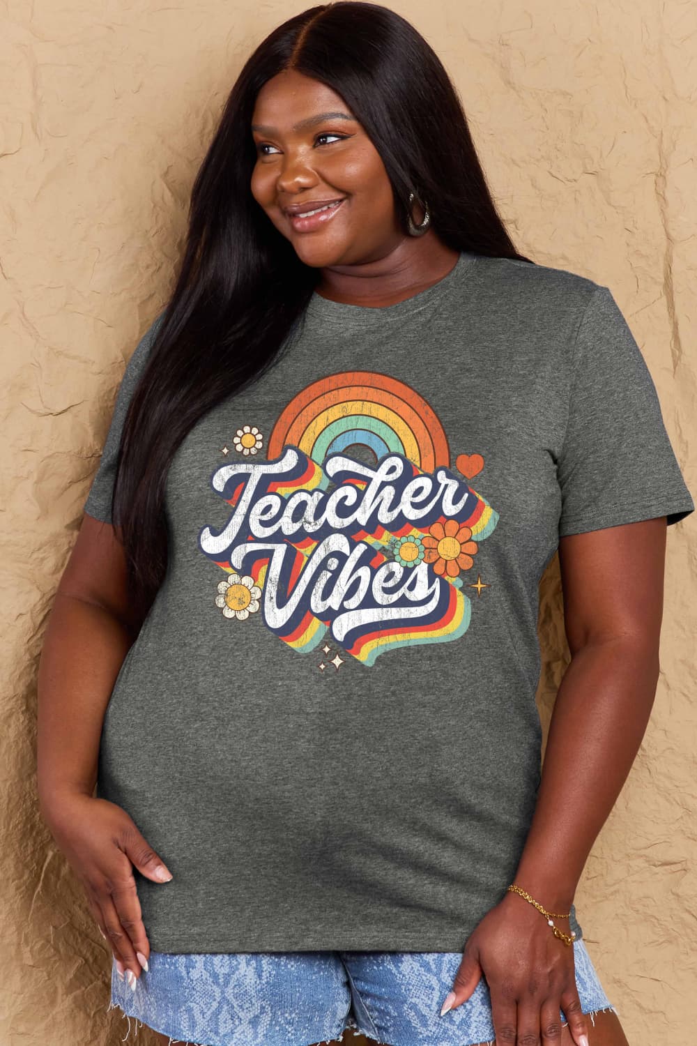 Woman wearing Graphic Cotton T-Shirt with 'TEACHER VIBES' design, ideal for casual wear and showcasing positivity and style.