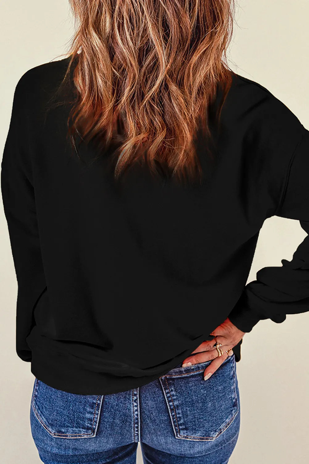 Back view of model wearing Spooky Sweatshirt with round neck and long sleeves, featuring glitter detailing for a stylish look.