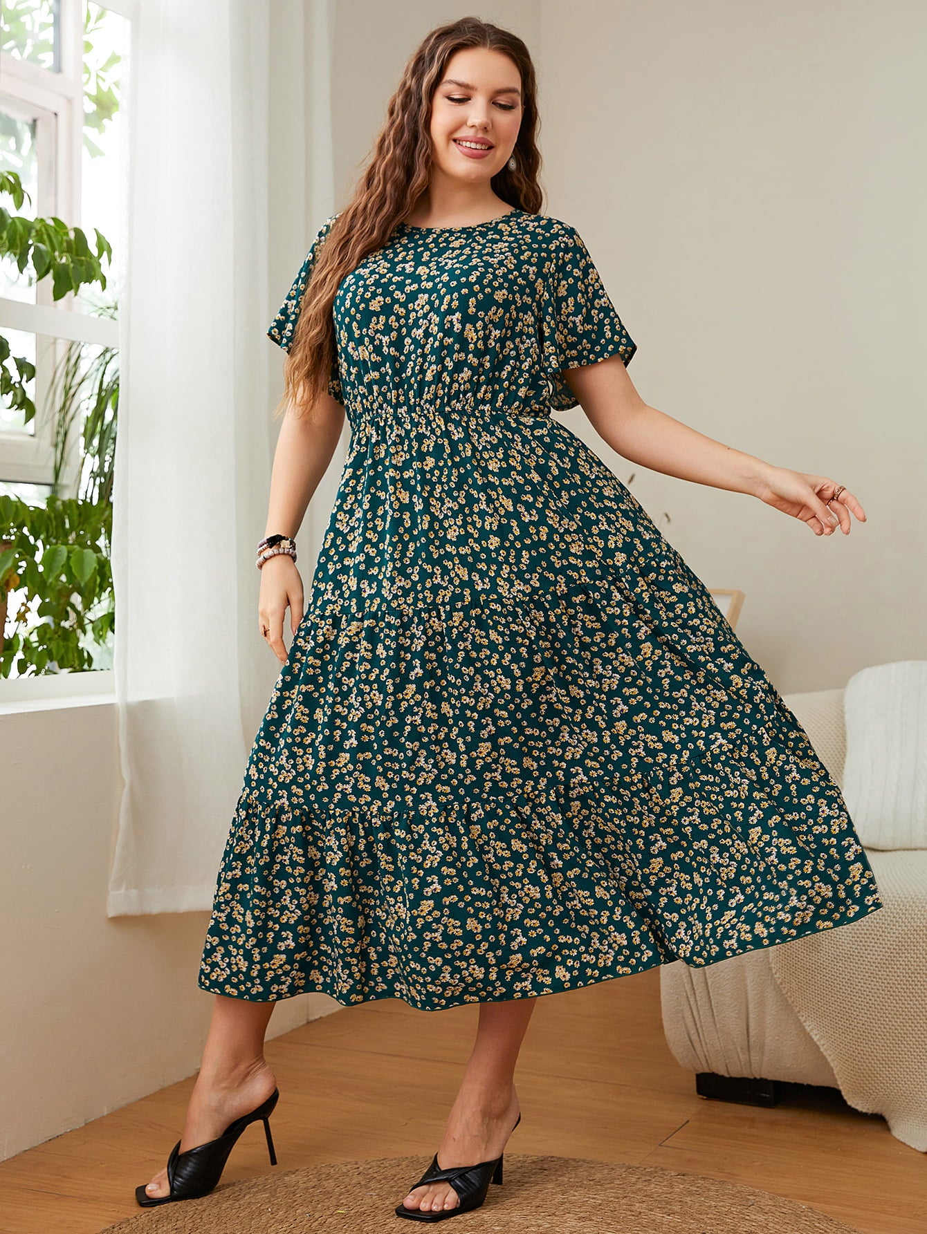 Woman wearing Floral Midi Dress, plus size round neck short sleeve, with flutter sleeves and A-line silhouette in a stylish room.